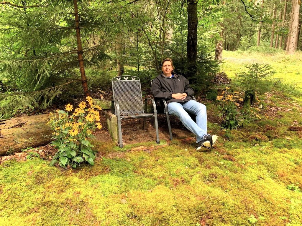 Bernhard Krebs im Wald auf einem Bankerl